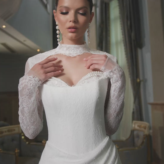 Bride in fitted lace wedding dress with sweetheart neckline, removable long-sleeve lace bolero, thigh-high slit, and chapel train.