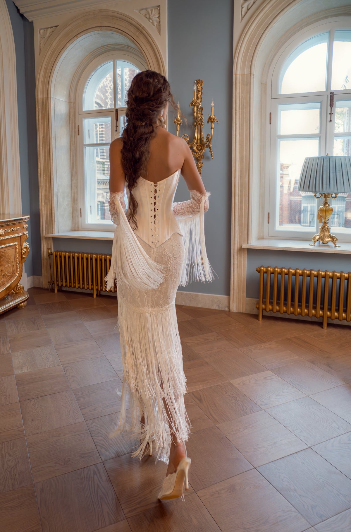 Strapless mikado corset wedding dress with fringe skirt – back view of the lace-up corset and lace sleeves