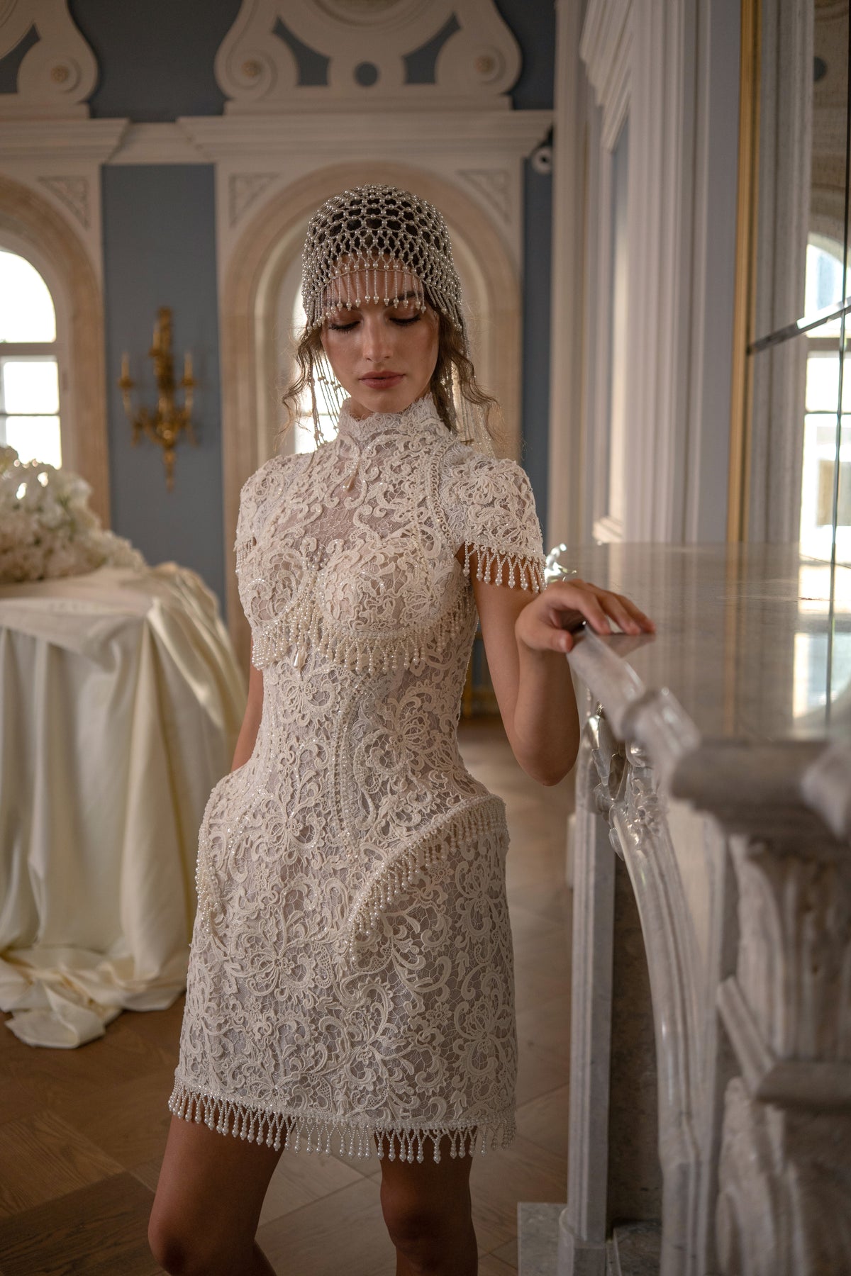 Lace mini wedding dress with high neck, cap sleeves and pearl fringe hem – front view