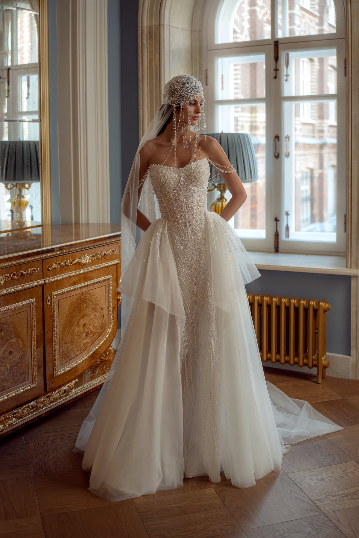 Beaded pearl corset wedding dress with layered tulle skirt – full-length front view by a palace window