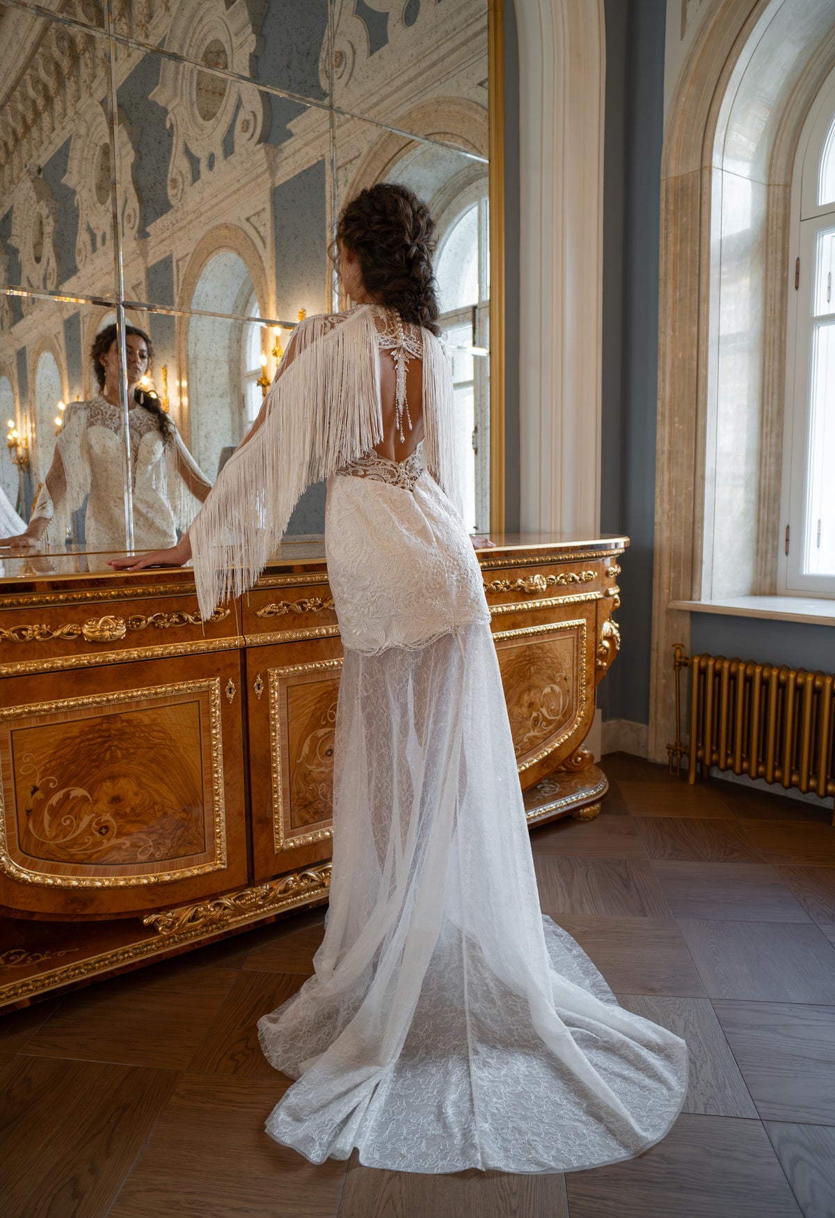 Lace wedding dress with fringe cape sleeves – back view of the open back and fitted train