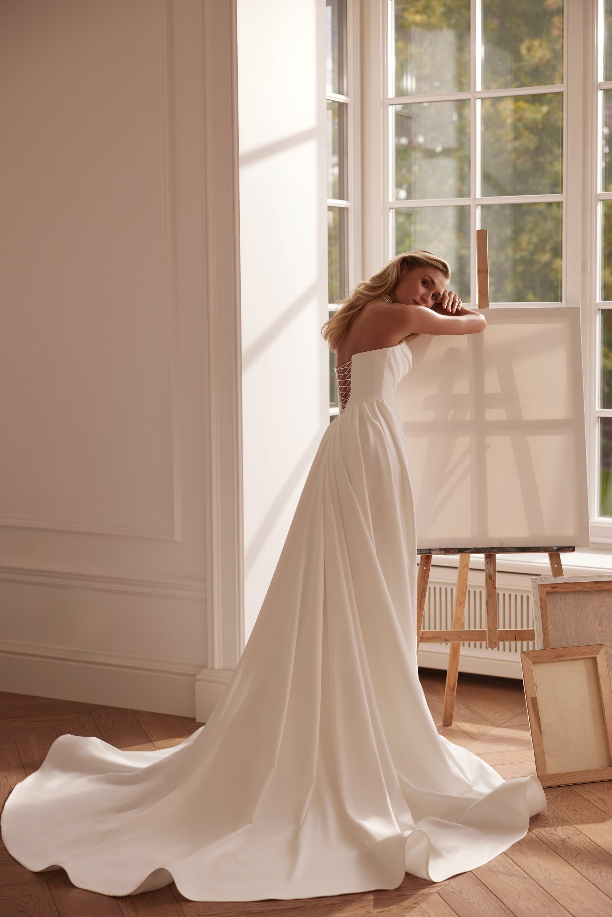 Strapless mermaid satin crepe wedding dress with draped bodice and flowing train.