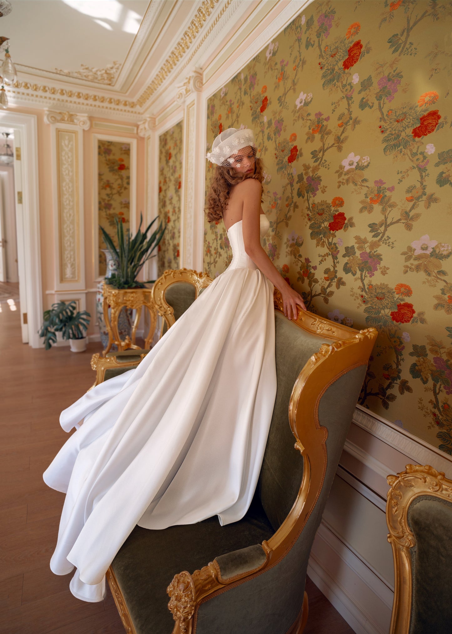 Strapless mikado bridal gown with sculpted slit and flowing train.
